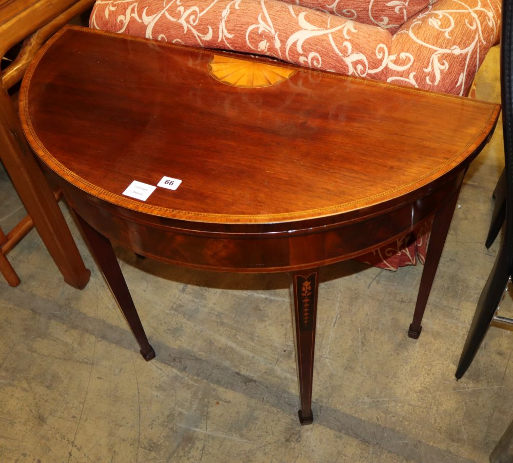 A George III mahogany tulipwood banded D shaped folding card table, chequer and husk inlaid, W.91cm